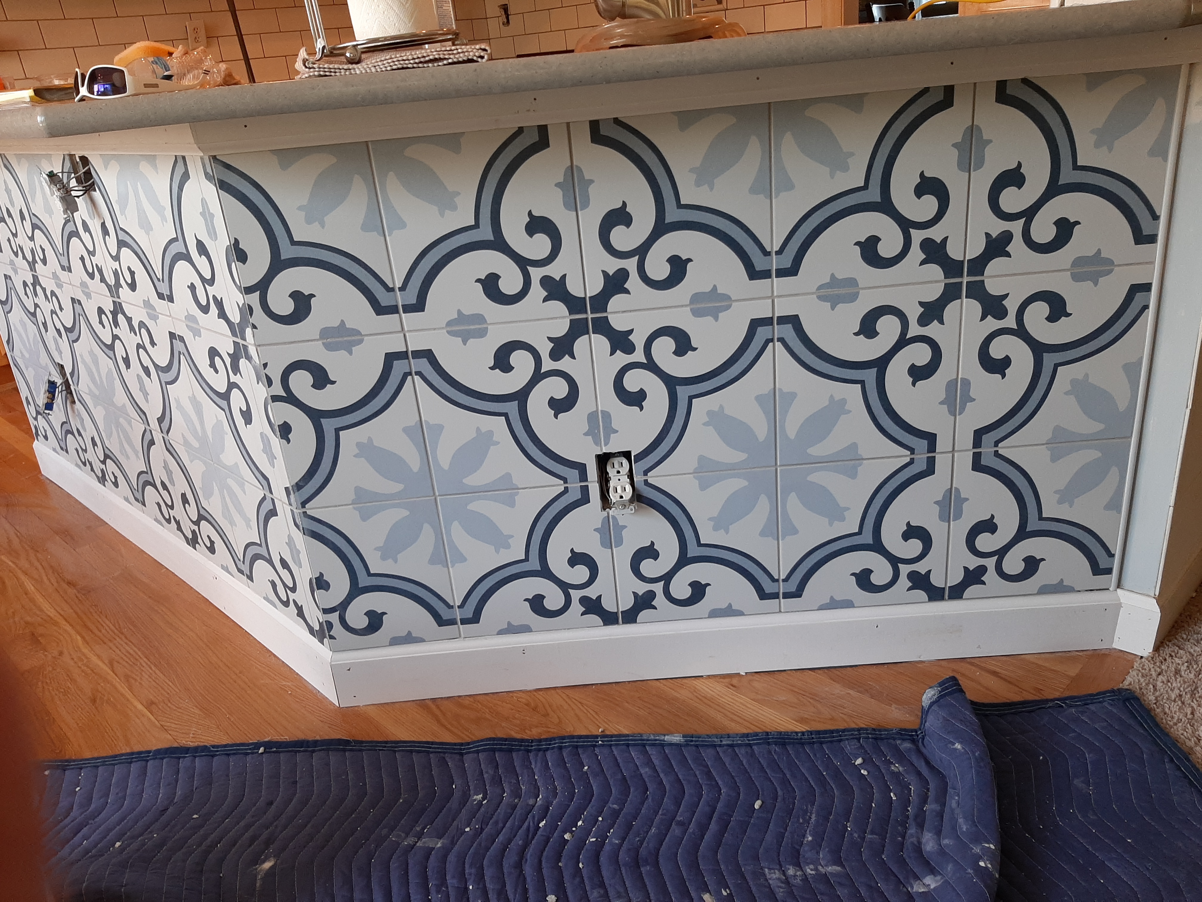 Kitchen island wrapped in patterned tile